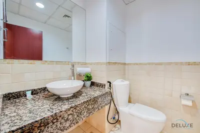 a bathroom with a toilet and a sink and a mirror at Vogue 2BR at Shams 2 JBR by Deluxe Holiday Homes in Dubai