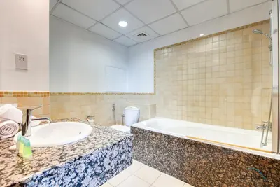 a bathroom with a sink and a bath tub at Vogue 2BR at Shams 2 JBR by Deluxe Holiday Homes in Dubai