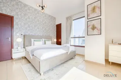 a bedroom with a large bed and a large window at Vogue 2BR at Shams 2 JBR by Deluxe Holiday Homes in Dubai