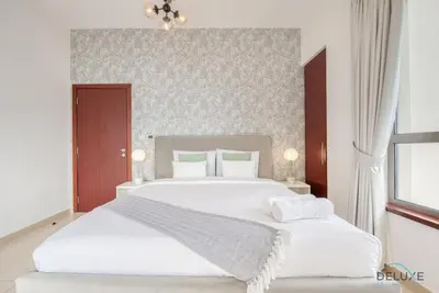 a bedroom with a large white bed and a window at Vogue 2BR at Shams 2 JBR by Deluxe Holiday Homes in Dubai