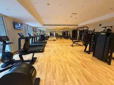 a gym with a row of treadmills and machines at Fully-equppied studio with private beach and pool in Dubai