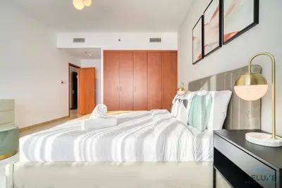 a bedroom with a large white bed and a desk at Opulent 1BR at MAG 218 Dubai Marina by Deluxe Holiday Homes in Dubai