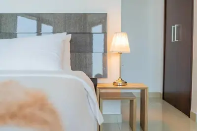 a bedroom with a bed and a table with a lamp at BellaVista - Huge Terrace 1BR Apartment 29 Boulevard Downtown with Burj Khalifa and Fountain Views in Dubai