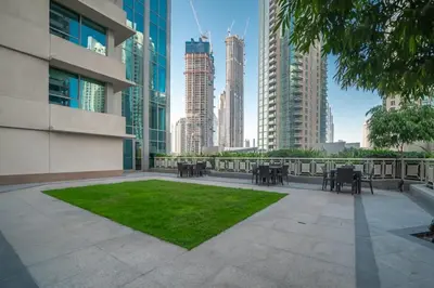 a patio in the middle of a city with tall buildings at BellaVista - Huge Terrace 1BR Apartment 29 Boulevard Downtown with Burj Khalifa and Fountain Views in Dubai
