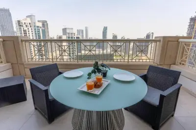 a table with a tray of food on a balcony at BellaVista - Huge Terrace 1BR Apartment 29 Boulevard Downtown with Burj Khalifa and Fountain Views in Dubai
