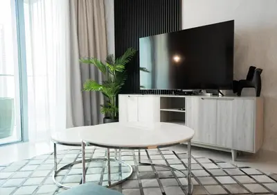 a living room with a table and a tv at Nasma Luxury Stays - The Grand, Dubai Creek Harbour in Dubai
