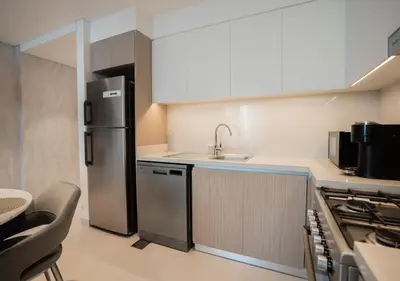 a small kitchen with a sink and a refrigerator at Nasma Luxury Stays - The Grand, Dubai Creek Harbour in Dubai