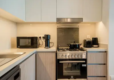 a kitchen with a stove and a microwave at Nasma Luxury Stays - The Grand, Dubai Creek Harbour in Dubai