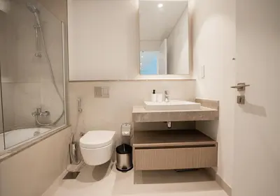 a bathroom with a sink and a toilet and a mirror at Nasma Luxury Stays - The Grand, Dubai Creek Harbour in Dubai