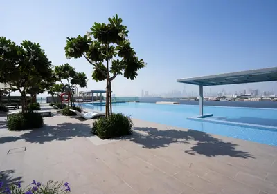 a swimming pool with trees and a view of the water at Nasma Luxury Stays - The Grand, Dubai Creek Harbour in Dubai