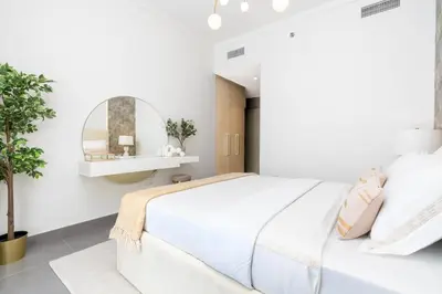 a white bedroom with a large bed and a mirror at ON OFF HH- CREEK HARBOUR-Lavish Parisian 2 BR in Dubai
