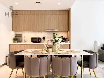 a kitchen and dining room with a table and chairs at Mira Holiday Homes - Newly 1 bedroom apartment with beach access in Dubai