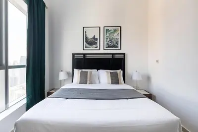 a bedroom with a large bed with green curtains at Frank Porter - Bay Central West 2 in Dubai