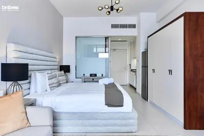 a bedroom with a large white bed and a couch at bnbme - Palm Jumeirah Studio Balcony Sea Ain Dubai Views Pool Gym Parking Access in Dubai