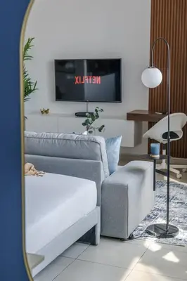 a living room with a couch and a chair and a mirror at GuestReady - Chic Studio in Urban JLT in Dubai