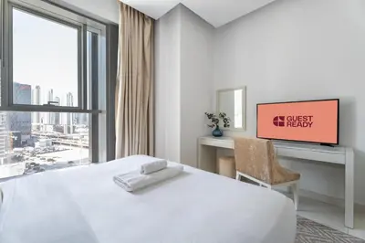 a bedroom with a bed and a desk and a window at GuestReady - Stylish Galore near Dubai Fountain in Dubai