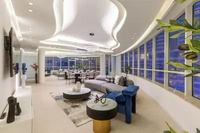 a living room with blue furniture and windows at Horizon Tower - Stunning Four Bedroom in Dubai