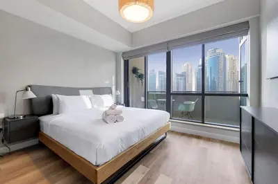 a bedroom with a bed with a teddy bear on it at Al Majara 2 - Gorgeous One Bedroom in Dubai