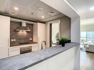 a kitchen with white cabinets and a counter top at Al Majara 2 - Gorgeous One Bedroom in Dubai