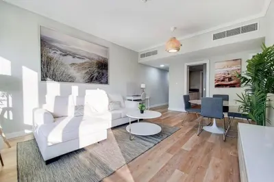 a living room with a white couch and a table at Al Majara 2 - Gorgeous One Bedroom in Dubai