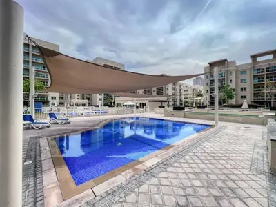 a large swimming pool with a hammock over it at Gorgeous One Bedroom Apartment in the heart of Dubai in Dubai