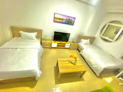a small room with two beds and a tv at Marina Crown Tower Stays Hostel for Girls in Dubai
