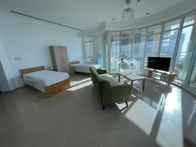 a bedroom with a bed and a chair and a television at Marina Crown Tower Stays Hostel for Girls in Dubai