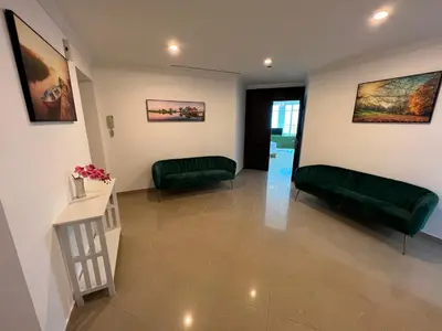 a living room with green furniture and paintings on the walls at Marina Crown Tower Stays Hostel for Girls in Dubai