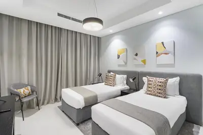 a hotel room with two beds and a chair at ALiving Luxury 2BR with Infinity Pool I Near Dubai Mall & Burj Khalifa I Paramount Hotel Midtown in Dubai