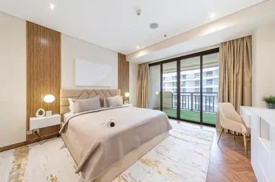 a bedroom with a large bed and a large window at EDEN'S Homes & Villas - Anantara The Palm Residences in Dubai
