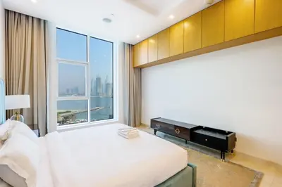a bedroom with a bed and a large window at Livbnb Suites - 1BR with Sea View & Beach Access in Dubai