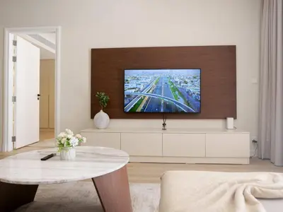 a living room with a tv on a wall at Lovely 1 bedroom apartment at 5 Star Resort in Dubai
