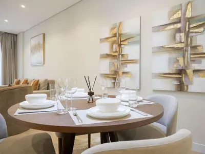 a dining room with a wooden table and chairs at Lovely 1 bedroom apartment at 5 Star Resort in Dubai
