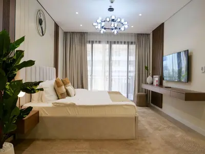 a bedroom with a large bed and a chandelier at Lovely 1 bedroom apartment at 5 Star Resort in Dubai