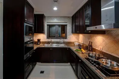 a kitchen with black cabinets and a sink and a stove at Durrani Homes - Souk Al Bahar Living Besides Burj khalifa & Fountain in Dubai