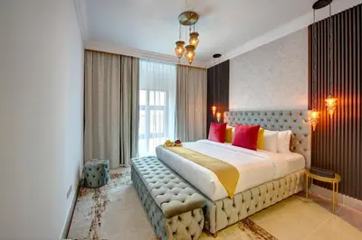 a bedroom with a large bed with a bench next to a window at Durrani Homes - Souk Al Bahar Living Besides Burj khalifa & Fountain in Dubai