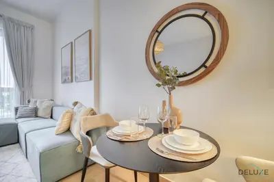 a living room with a table and a mirror at Placid 1BR at La Cote 5 Jumeirah 1 by Deluxe Holiday Homes in Dubai
