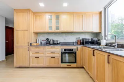 a kitchen with wooden cabinets and a sink at Downtown Luxury I 5 Min Walk To Dubai Fountain! in Dubai