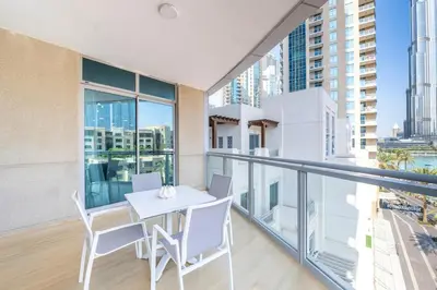 a balcony with a white table and chairs on it at Downtown Luxury I 5 Min Walk To Dubai Fountain! in Dubai