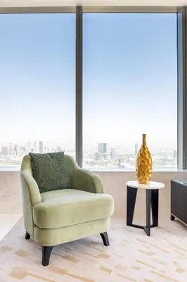 a living room with a green chair and a vase on a table at Ultra Luxury Palm Tower with Shared Hotel Facilities in Dubai