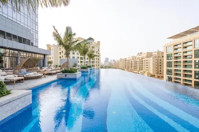 a large swimming pool in a city with buildings at Ultra Luxury Palm Tower with Shared Hotel Facilities in Dubai