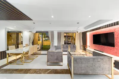 a living room with a tv and a table and chairs at ELAN RIMAL SADAF Suites in Dubai