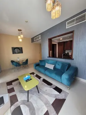 a living room with a blue couch and a table at Bellavista - Glamorous - 2BR - 29 Boulevard - Burj Khalifa & Fountain View in Dubai