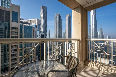 a balcony with a table and chairs and a view of the city at Bellavista - High Floor - 1BR - 29 Boulevard - Full Burj Khalifa & Fountain View in Dubai