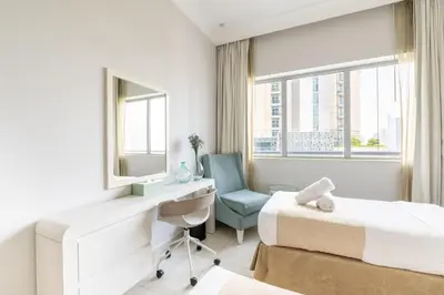 a hotel room with two beds and a desk and a chair at Damac Mall Street Residences in Dubai