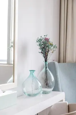 two vases sitting on a table with flowers in them at Damac Mall Street Residences in Dubai
