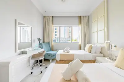 a hotel room with two beds and a desk at Damac Mall Street Residences in Dubai