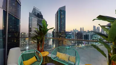 a balcony with chairs and a view of a city at High-End Designer Penthouse Full Burj Khalifa View in Dubai