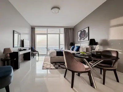 a bedroom with a bed and a table and chairs at Trophy Stays - Peaceful Golf side Escape Studio - Damac Hills in Dubai