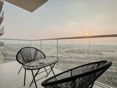 a balcony with two chairs and a table at Trophy Stays - Peaceful Golf side Escape Studio - Damac Hills in Dubai